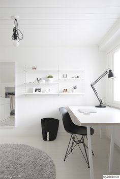 a white room with two black chairs and a desk