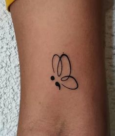 a small tattoo on the side of a woman's leg that has an abstract design