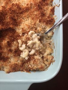 a close up of a plate of food with meat and cheese on it, next to a fork