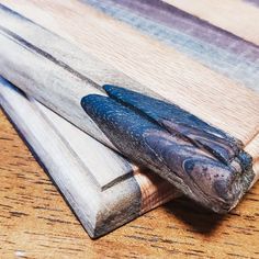 a pair of scissors sitting on top of a wooden cutting board