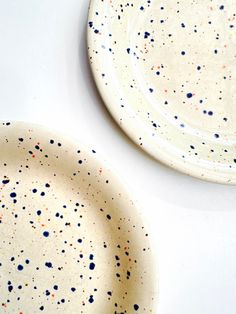 two white plates with multicolored speckles on them