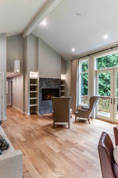 a living room filled with furniture and a fire place next to a large open window