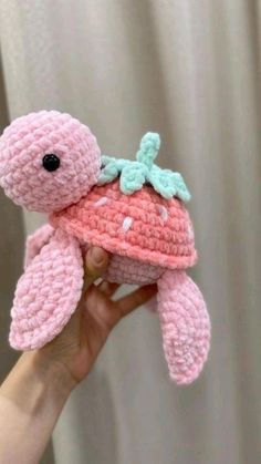 a pink crocheted stuffed animal with a green bow on it's head