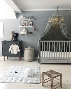 a baby's room with grey walls and white furniture