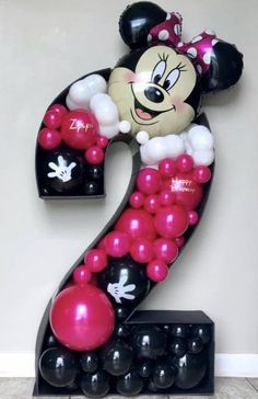 the number two is made up of balloons and minnie mouse balloon numbers are black, white, and pink