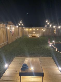 an outdoor patio with lights on it and a coffee table in the foreground at night