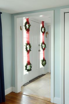 two wreaths are hanging on the front door