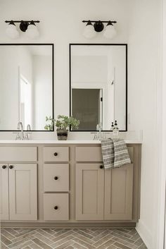 a bathroom with double sinks and two mirrors