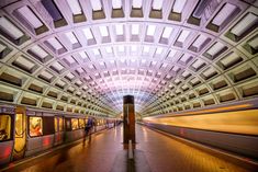 a train traveling through a subway station next to tall buildings