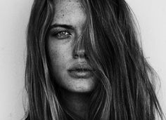 a black and white photo of a woman with freckled hair