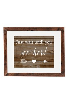 a wooden framed sign with the words just wait until you see her and an arrow