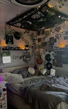 a bed room with a neatly made bed and lots of pictures on the wall above it