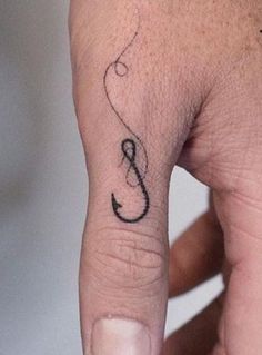 a person's finger with a musical note tattoo on it