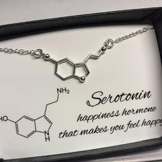 a necklace with the words serotronn on it in a box that says, what makes you feel happy?