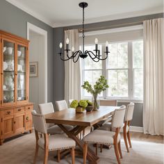 a dining room table with white chairs and a chandelier