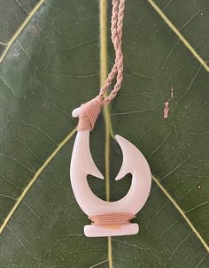 Maori Hei Matau New Zealand Fish Hook Buffalo Bone Pendant with Adjustable Cotton Cord Necklace Pendant:  Approx. 2" long, 1" wide Cord Necklace:  Approx. 28" long (Adjustable) Maori Necklace, Maori Hook, Handmade White Fish-shaped Jewelry, Fish Bone Earrings, Maori Fish Hook Necklace, Mako Mermaids Necklace, Cotton Cord Necklace, Bone Necklace, Bone Pendant