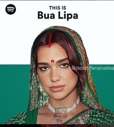 a woman with red hair wearing a green sari and jewelry on her head, in front of a white sign that says this is bua lipa