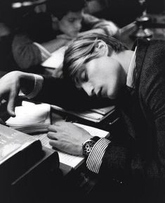 black and white photograph of a man sleeping on a desk