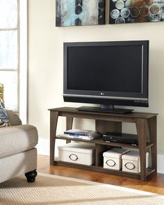 a flat screen tv sitting on top of a wooden stand