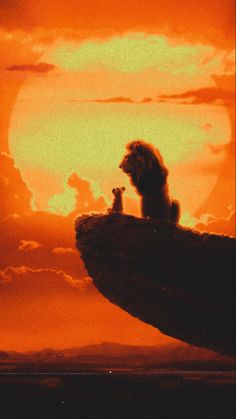 the lion and the mouse are sitting on a rock in front of an orange sky