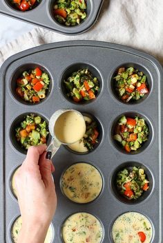 someone pouring dressing into a muffin tin filled with cupcakes and veggies