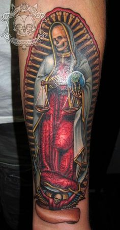 a man with a tattoo on his arm that has a lady justice statue in it