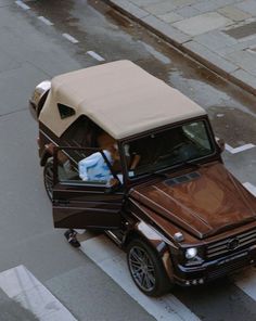 a car with a covered top driving down a street next to a sidewalk and traffic light