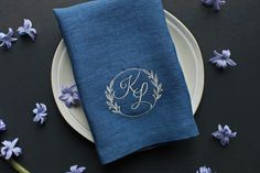 a plate with a napkin on it next to purple flowers