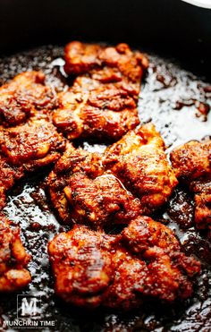 some meat is cooking in a skillet on the stove with sauce and seasoning