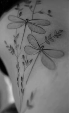 a woman's back with dragonflies on it