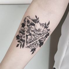 a woman's arm with flowers on it and a cross in the middle is shown