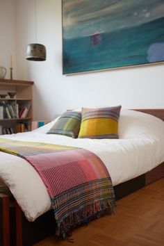 a bed sitting in a bedroom next to a book shelf