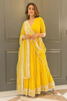 Yellow angrakha anarkali with mirror and thread embroidery all-over and a ruffle layered trim on the hem. Comes with sheer dupatta.
Components: 2
Pattern: Embroidery
Type Of Work: Thread and Mirror
Neckline: V neck
Sleeve Type: Three Quarter
Fabric: Angrakha: Cotton Mulmul and Dupatta: Tulle and Soft Net; Lining: Shantoon
Color: Yellow
Other Details: 
Sheer dupatta with mirror work and lace trim on the border
Layered anarkali
Overlap style V neckline
Tie up on the side
Note: The sharara set worn Navratri Maxi Sets With Gota Work, Navratri Gota Work Maxi Length Sets, Maxi Length Sets With Gota Work For Navratri, Festival Sharara With Chikankari Embroidery, Festival Chikankari Embroidery Maxi Length Sharara, Festival Maxi Length Sharara With Chikankari Embroidery, Yellow Georgette Anarkali Set For Transitional Season, Anarkali Style Sharara With Mirror Work, Diwali Chikankari Anarkali Set