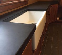 a white sink sitting under a window in a kitchen