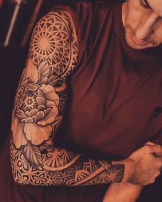 a man with a flower tattoo on his arm