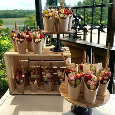 an assortment of food items displayed on wooden trays in front of a balcony overlooking the water