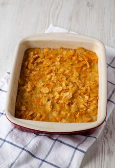 a casserole dish filled with food sitting on top of a blue and white towel