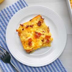 a white plate topped with an omelet next to a fork