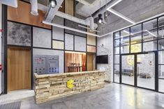 the interior of an office building with stone walls and wood paneling on the front desk