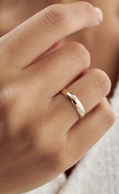 a woman's hand with a gold ring on it