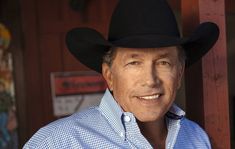 a man wearing a cowboy hat standing in front of a building