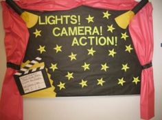 a sign that says lights camera action on the side of a wall with red curtains