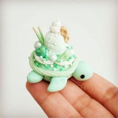 there is a small toy turtle on top of a cupcake with mints and marshmallows