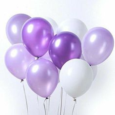 a bunch of balloons that are in the shape of an elephant on sticks with some white and purple balloons attached to them