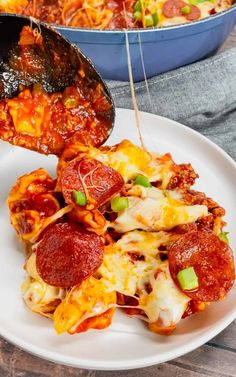 a white plate topped with pepperoni and cheese covered pizza next to a skillet