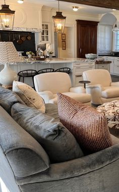 a living room filled with furniture next to a kitchen