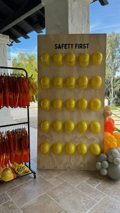 there is a safety first sign in front of some oranges and balloons on the floor