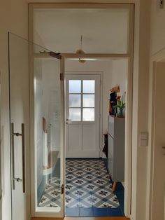 an open door leading to a bathroom with tiled floors