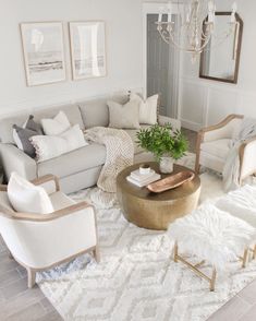 a living room filled with furniture and a chandelier hanging from the ceiling above