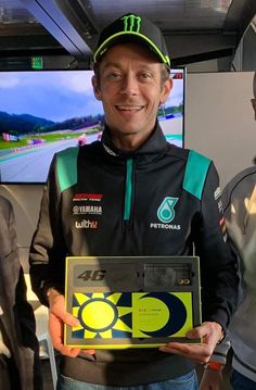 a man holding an award in front of two other men